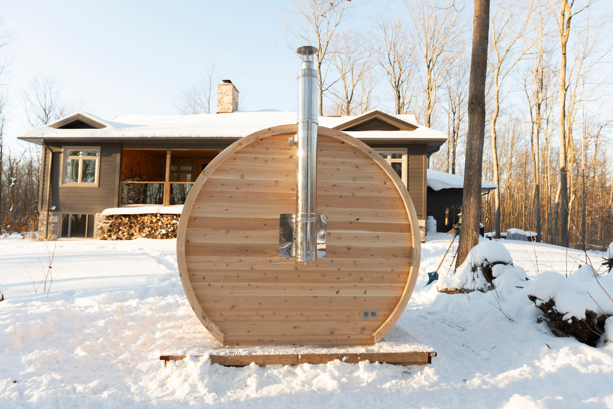 CT Elation sauna installed beside a residence with the chimney venting in winter