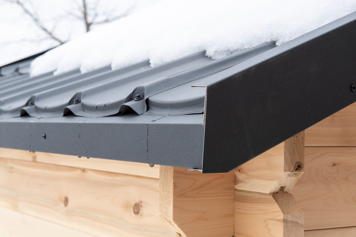 Snow sitting on the CT Granby cabin sauna metal roof and eave
