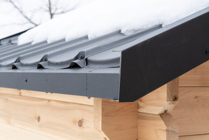 Snow sitting on the CT Granby cabin sauna metal roof and eave