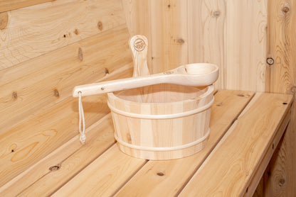 Close-up of the cedar sauna bucket and ladle resting on the CT Harmony bench