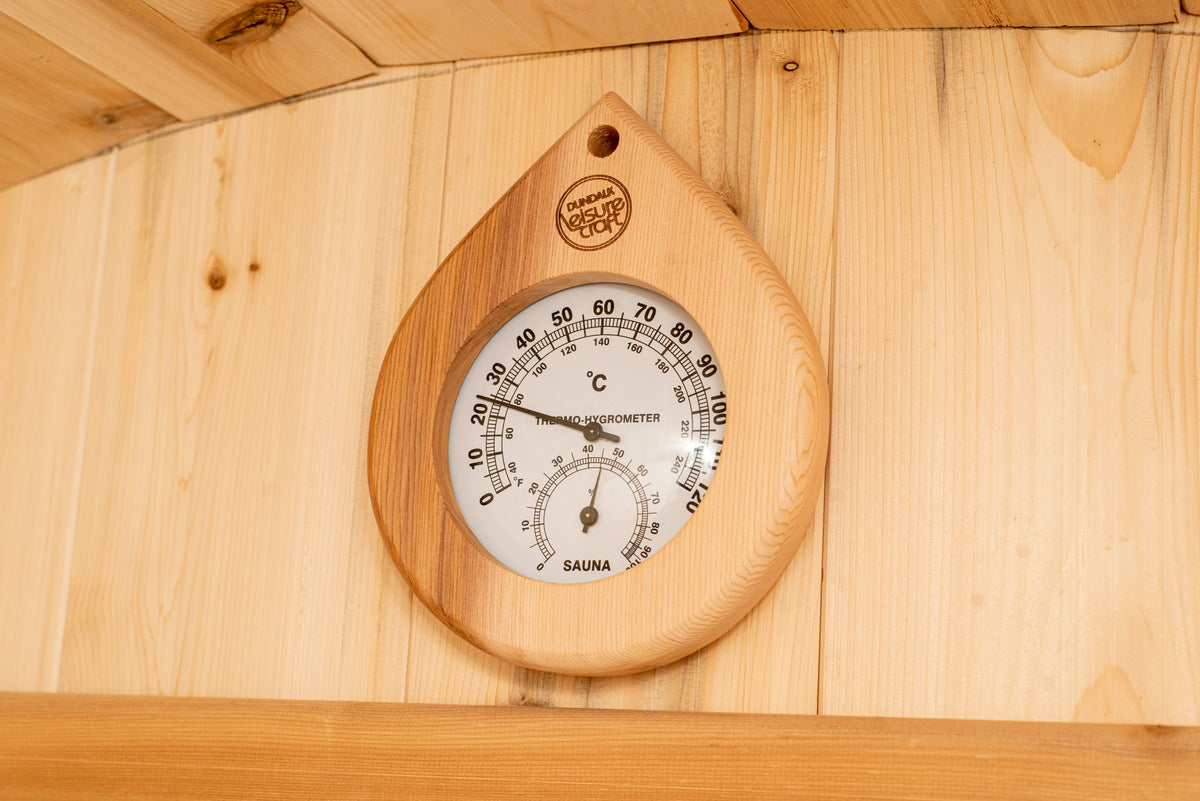 Close-up of the teardrop cedar thermometer and hygrometer mounted inside the CT Harmony barrel sauna