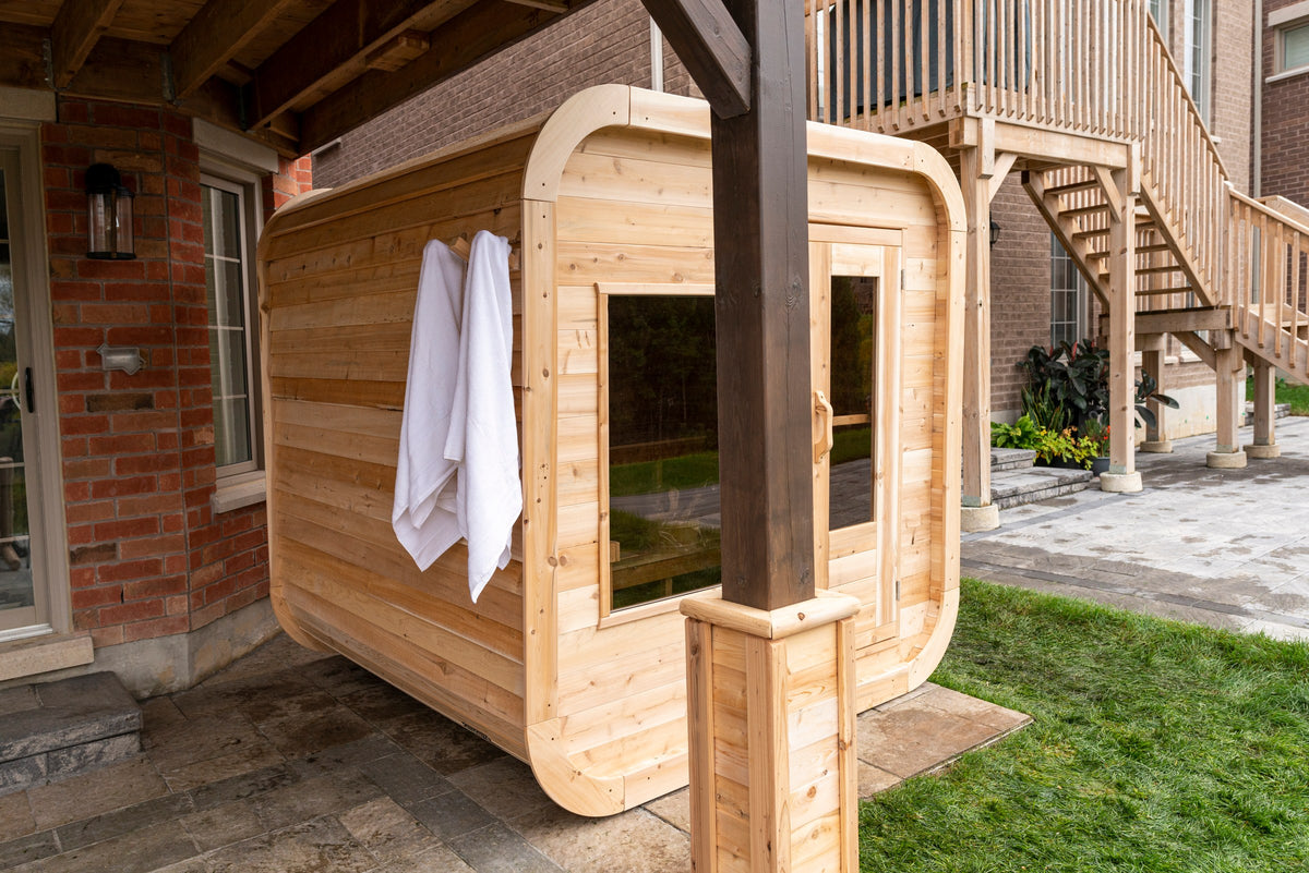 CT Luna sauna in a garden setting beside a brick residence