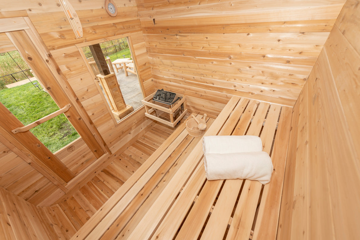 CT Luna sauna interior looking toward the glass door and side window with the electric heater and folded towels on the bench
