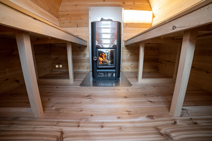 CT MiniPOD sauna interior with facing cedar benches and the wood stove
