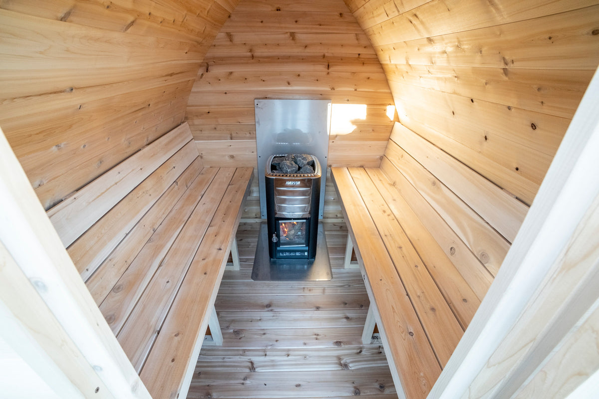 CT MiniPOD sauna interior looking toward the stove under the curved cedar ceiling