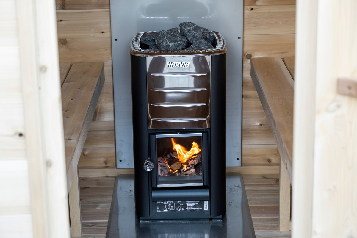 Wood stove burning inside the CT MiniPOD sauna with stones on the tray