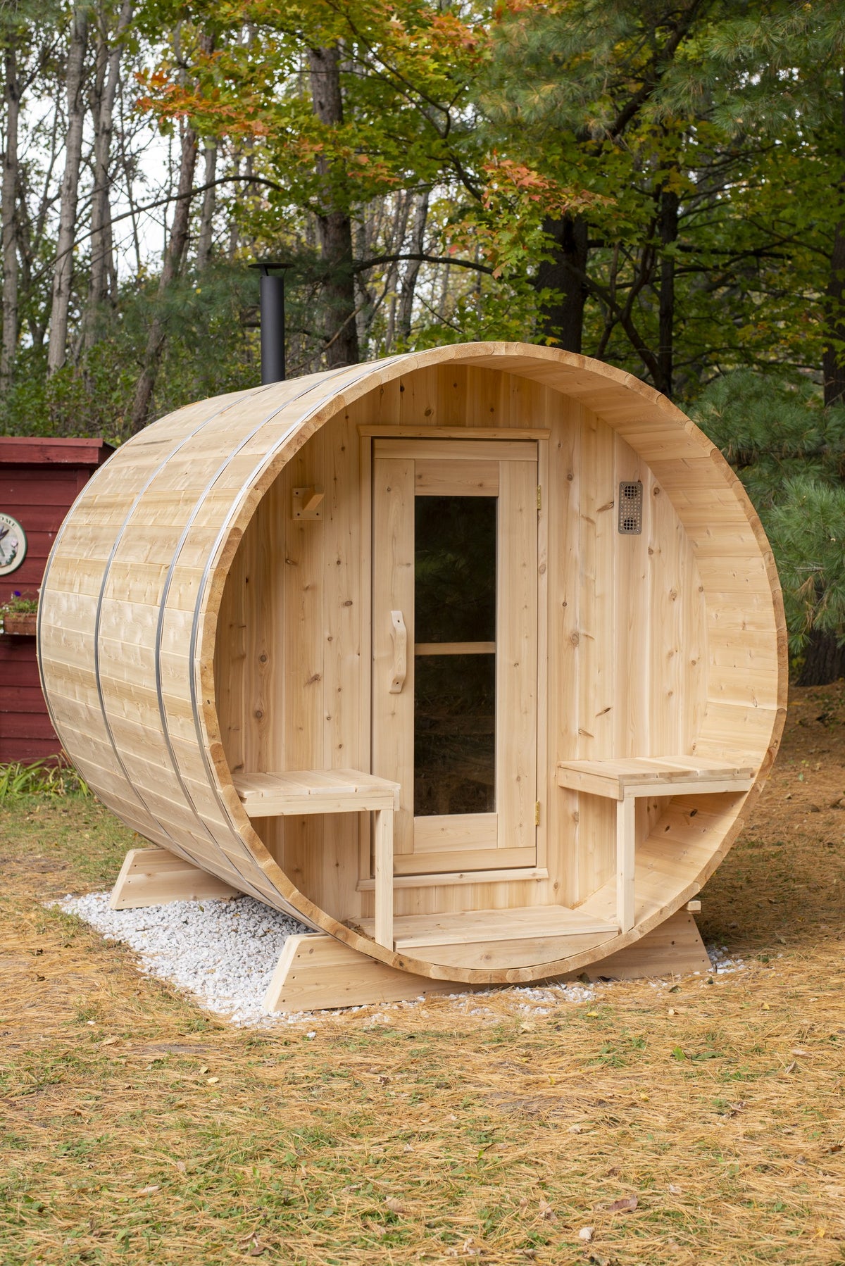 CT Serenity cedar barrel sauna installed outdoors with chimney and autumn treeline