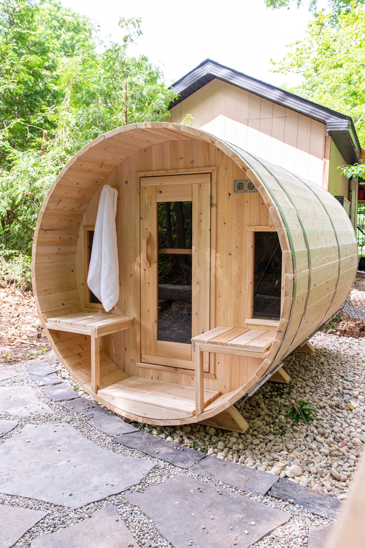 CT Tranquility barrel sauna front with a towel hung on the porch, styled outdoors