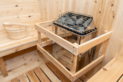 Close view of the CT Tranquility sauna heater loaded with stones behind its guard rail